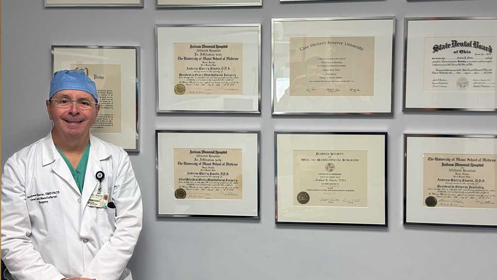 dr-slavin-by-wall-with-accreditations-good-samaritan-dental-implants